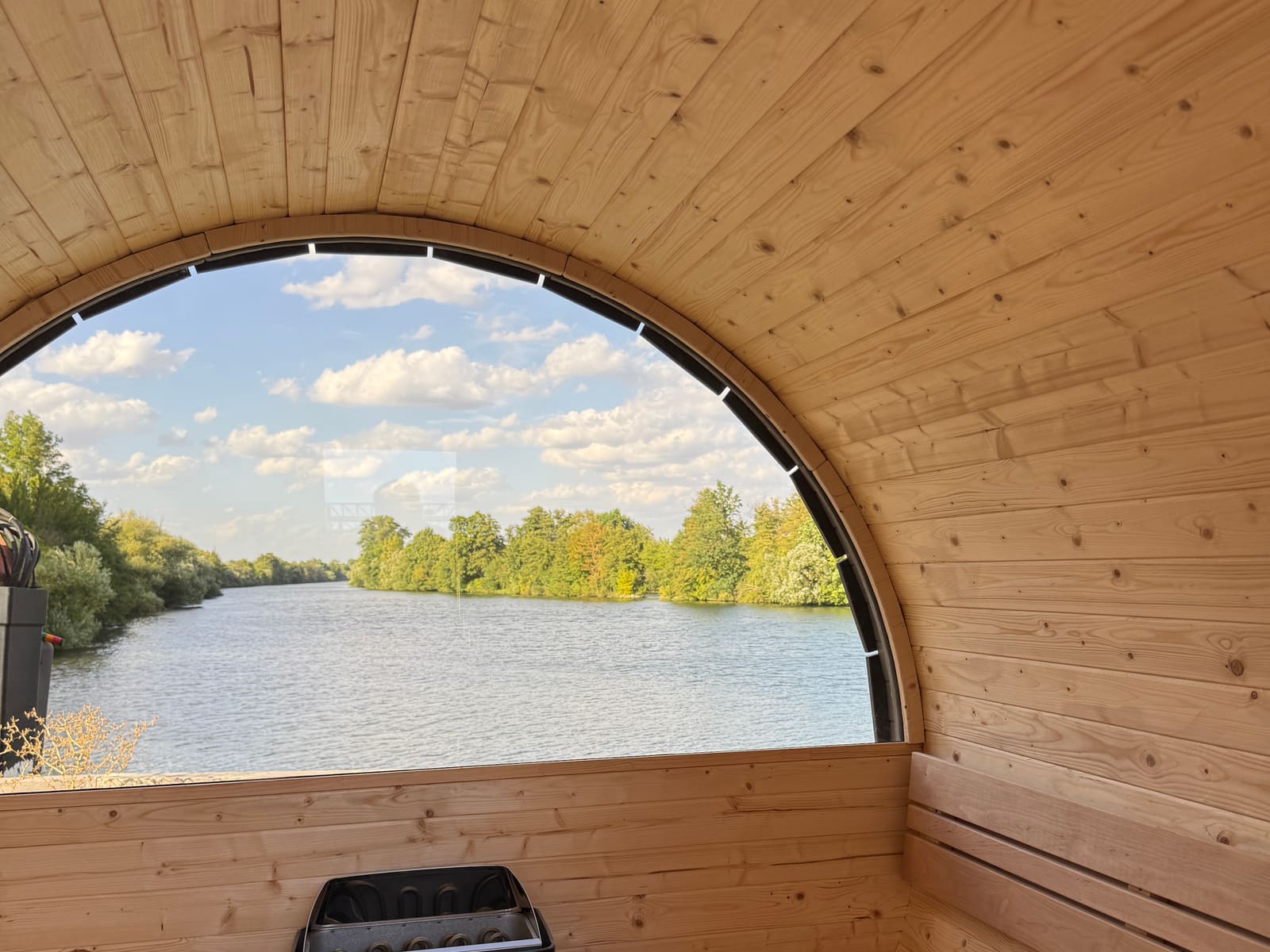 View from the barrel sauna through the round window onto the water